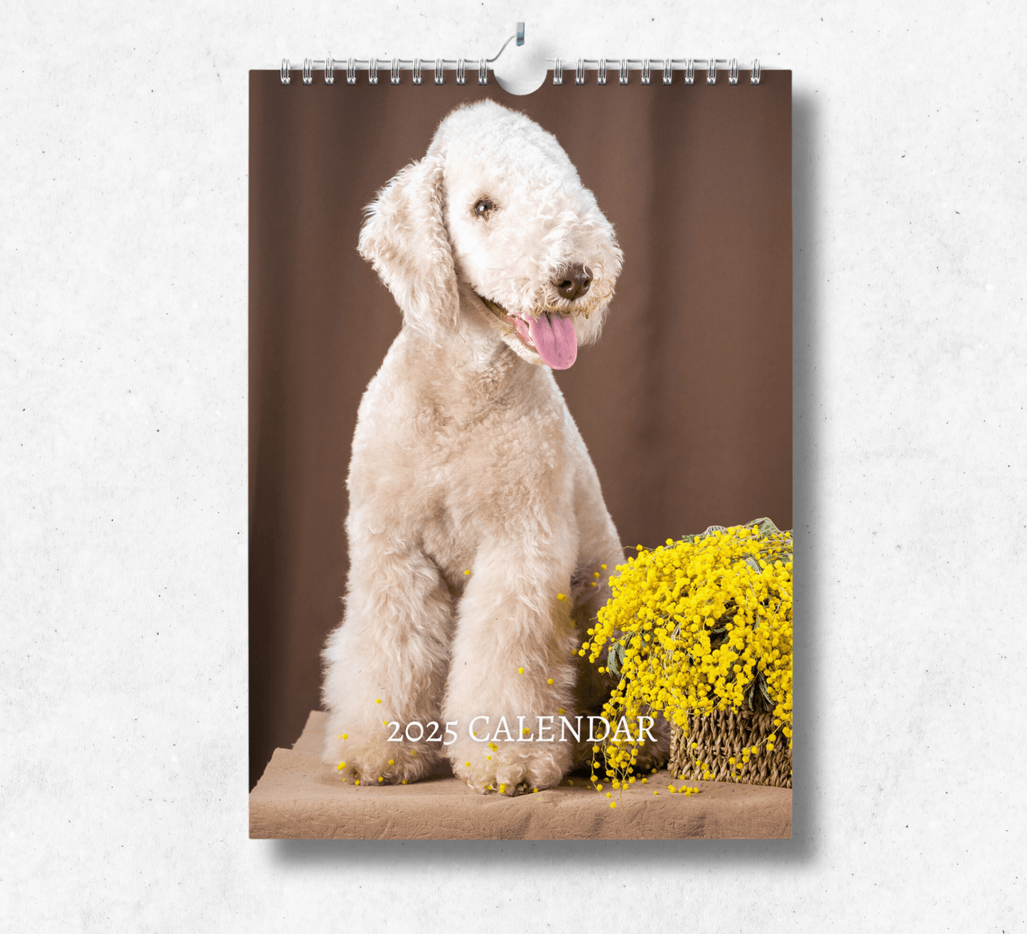 2025 Bedlington Terrier calendar featuring a panting bedlington terrier, sitting next to a bouqet of yellow flowers.