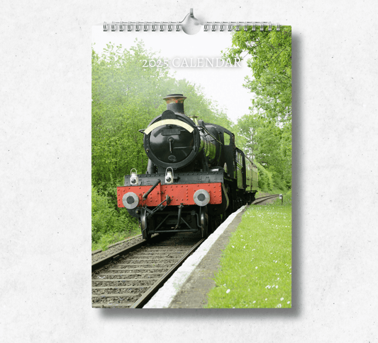 2025 Steam Train calendar with a wire binding and hanger, featuring a black steam train on the tracks going through a forrest.